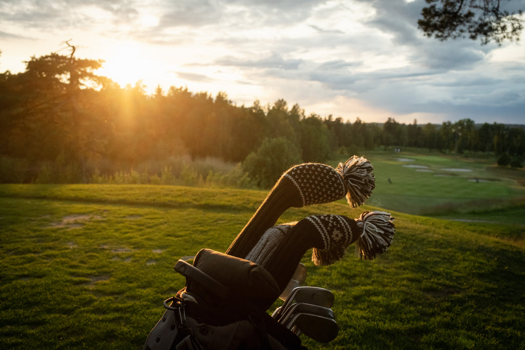 Knit wool golf headcovers with Nordic patterns on golf bag at sunset – premium golf accessories with character and tradition